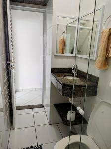 a bathroom with a toilet and a sink and a shower at Apto frente ao mar in Peruíbe