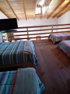 a room with two beds and a flat screen tv at Hermosa y cálida casa tipo cabaña in Creel