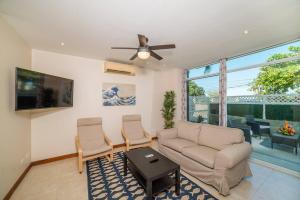 a living room with a couch and a ceiling fan at Flamingo Zueños del Mar Condominiums in Playa Flamingo