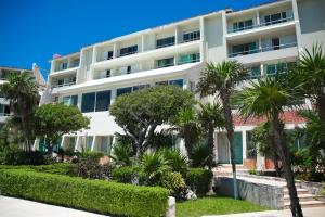 ein großes weißes Gebäude mit Palmen davor in der Unterkunft Solymar Cancún beachfront condos in Cancún