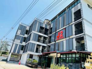 un bâtiment avec un panneau sur son côté dans l'établissement J2 Residence Chiang Rai, à Chiang Rai