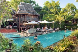 a group of people in a swimming pool with a house at Baansuwanburi - บ้านสุวรรณบุรี in Chiang Mai