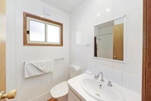 Un baño blanco con lavabo y espejo. en Narrawong Island Holiday Park, en Narrawong 18 fotos más