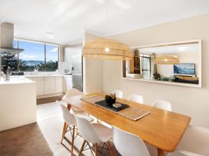 a kitchen and dining room with a wooden table and chairs at Avalanche 6 Stylish Modern Apartment in Central Location in Jindabyne