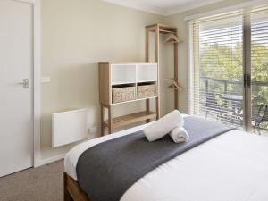 a bedroom with a large bed with a window at Caribou 3 Views over Lake Jindabyne with Wifi in Jindabyne