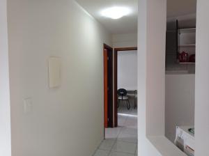 um corredor com paredes brancas e uma porta para um quarto em Bessa João Cabral a 50 metros da praia em João Pessoa