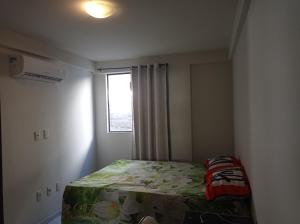um pequeno quarto com uma cama e uma janela em Bessa João Cabral a 50 metros da praia em João Pessoa