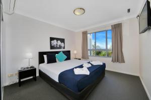 a bedroom with a bed and a window at The Point Resort in Bargara +18 photos
