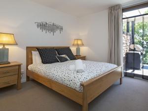 a bedroom with a large bed and a window at The Edge Apartment 5 Jindabyne in Jindabyne