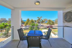 a dining room with a table and chairs on a balcony at The Point Resort in Bargara