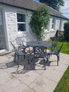a black table and chairs sitting around a patio at Barcloy Honey House in Kirkcudbright