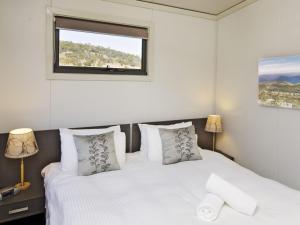 sypialnia z 2 łóżkami i oknem w obiekcie Ecocrackenback 19 Sustainable chalet close to the slopes w mieście Crackenback