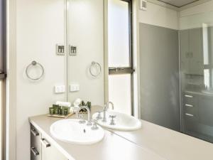 a white bathroom with two sinks and a shower at Ecocrackenback 19 Sustainable chalet close to the slopes in Crackenback +11 photos