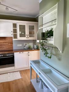 una cucina con mobili bianchi e tavolo di S´Kraftplatzl a Bad Aussee