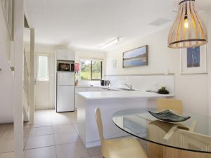 a kitchen with a glass table and a dining room at Lakeside Townhouse - 2BR Modern Townhouse l Lake Views l Balcony l Walking Distance To Town in Jindabyne