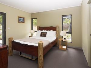 a bedroom with a bed and two windows at Kickenback Chalet Contemporary chalet in the heart of Crackenback in Crackenback