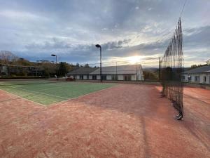 a tennis court with a net on top of it at Horizons 216 - Deluxe Lake Front Studio l Pool l Tennis l Air-Con in Jindabyne