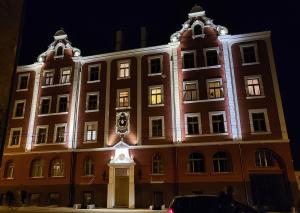un gran edificio con un reloj delante en Cozy Storie's AP, 47sqm, Renovated 2020, Free parking, en Riga