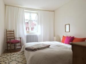 um quarto com uma cama, uma cadeira e uma janela em kirchgässlein em Dinkelsbühl