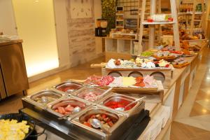 una línea de buffet con muchos tipos diferentes de comida en Hotel Córdoba Centro, en Córdoba