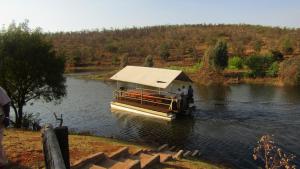 a boat on a river with people on it at Zebra Nature Reserve in Cullinan