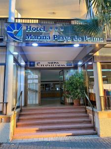エル・アレナルにあるHotel Marina Playa De Palmaのホテル町並み広場の椰子を読む看板のある建物