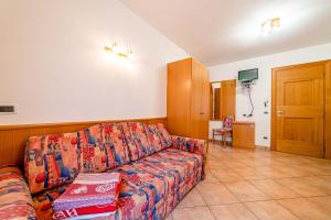 Appartamenti Ciesa Padon في روكا بييتوري: غرفة معيشة مع أريكة وتلفزيون