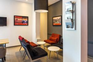 uma sala de espera com cadeiras e mesas e quadros na parede em Red Planet Bangkok Asoke - SHA Extra Plus em Bangkok