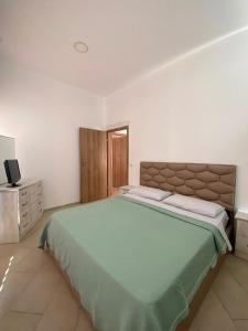 a bedroom with a large bed and a television at eri apartament in Himare