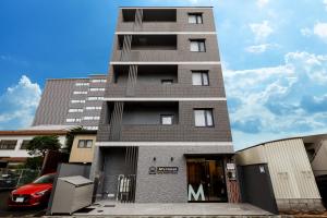 a tall building with a car parked in front of it at M's Hotel Kyoto Station Kizuya in Kyoto