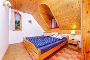 a bed in a room with a wooden ceiling at Holiday home Balatonbereny 18059 in Balatonberény