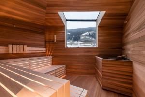 a sauna with a large window and wooden walls at Boutique & Gourmet Hotel Orso Grigio in San Candido