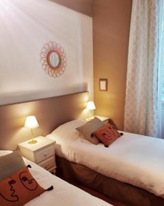 a hotel room with two beds and a mirror at Hotel Restaurant Le Bosquet in Les Ponts-de-Cé