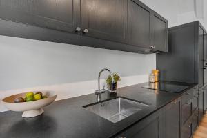a kitchen with a sink and a bowl of fruit on the counter at Sanders Regent - Smart Two-Bedroom Apartment Near Central Square in Copenhagen