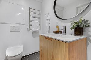 a bathroom with a sink and a toilet and a mirror at Sanders Regent - Smart Two-Bedroom Apartment Near Central Square in Copenhagen +24 photos