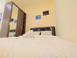 sypialnia z białym łóżkiem z dużym lustrem w obiekcie La Tana Hotel w mieście Bagongsabrangan