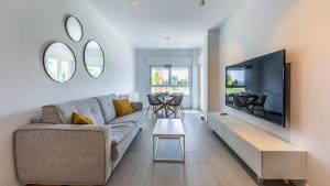 Homity Exclusive Playa Granada Beach & Golf - Marina Golf في موتريل: غرفة معيشة مع أريكة وتلفزيون
