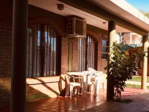 un patio con mesa y sillas en un edificio en Aoniken Cabañas en Villa Cura Brochero