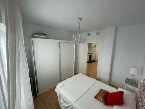 タリファにあるApartamento Vacacional Manoliのベッドルーム1室(白いベッド1台、赤い枕付)