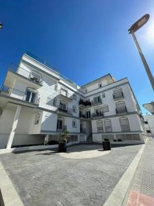 タリファにあるApartamento Vacacional Manoliの中庭付きの白い大きなアパートメントです。