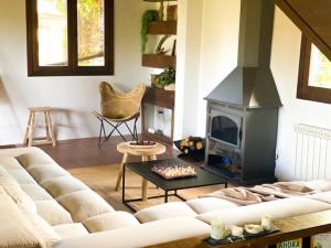 a living room with a couch and a fireplace at EL CUENTO DE LA ENCINA. Un espacio para sentir in Majaelrayo