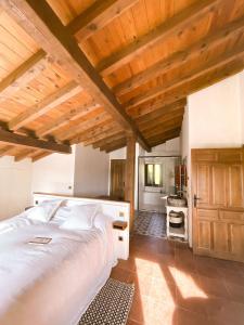a bedroom with a large bed and a wooden ceiling at EL CUENTO DE LA ENCINA. Un espacio para sentir in Majaelrayo