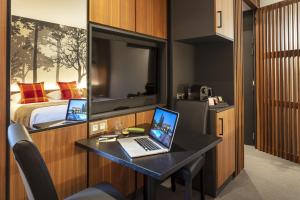 a room with a desk with a laptop and a bed at Auberge Les Murets in Chandolas