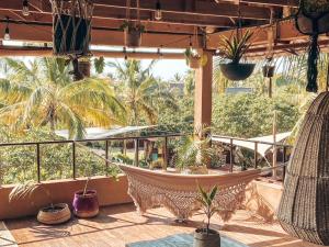 a hammock on the balcony of a resort with palm trees at Mozambeat Motel in Praia do Tofo