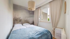 a bedroom with a bed and a window at Baltic Sun, Sun & Snow in Sztutowo