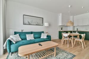 a living room with a green couch and a table at LTC - Apartments Abrahama Śródmieście in Gdynia