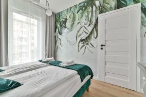 a bedroom with a bed and a wall mural at LTC - Apartments Abrahama Śródmieście in Gdynia