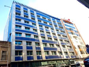 Jura Hotels Mavi Sürmeli Adana في أضنة: مبنى أزرق طويل مع الكثير من النوافذ