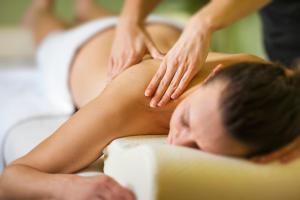 uma mulher a receber uma massagem de um terapeuta em Maxmilian Lifestyle Resort em Loucen