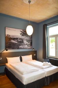 a bedroom with a large white bed with a ceiling at Storyhotel Bergischer Hof Königswinter in Königswinter